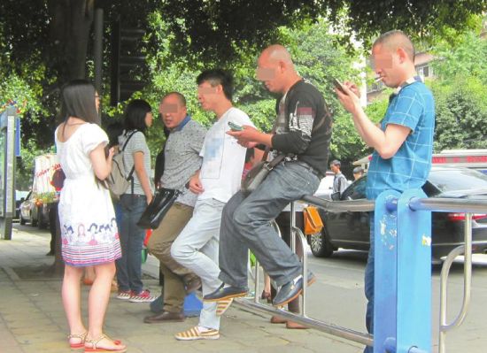 5月26日，四川大学华西医院附近，几名“号串串”正劝说行人找他们挂号。